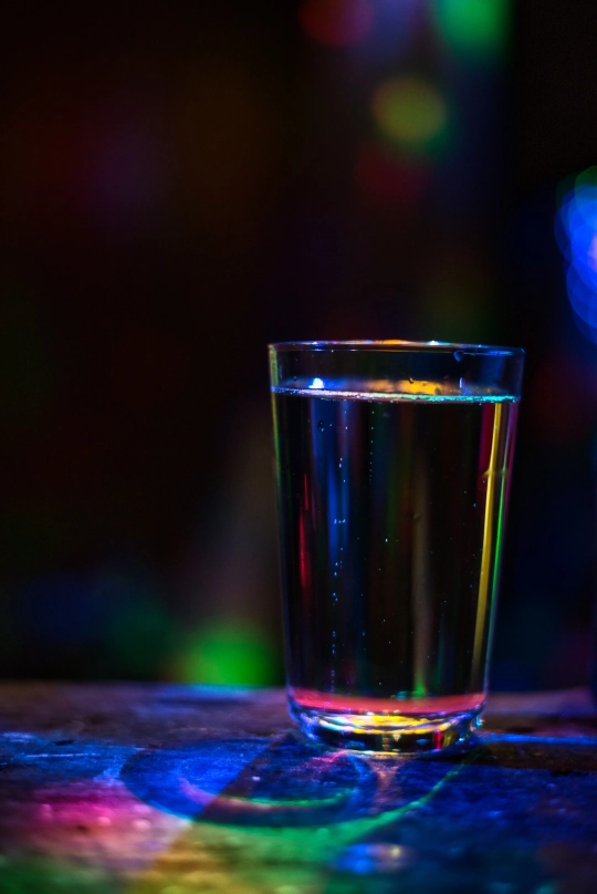 Ein Bild eines Glasses Wasser, bei einer Party in der Nacht.